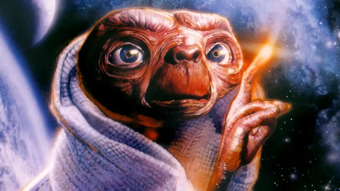 E.T. z filmu o kosmitach lat 80. otulony kocem, z palcem wskazującym w stronę świecącego punktu na tle kosmosu.