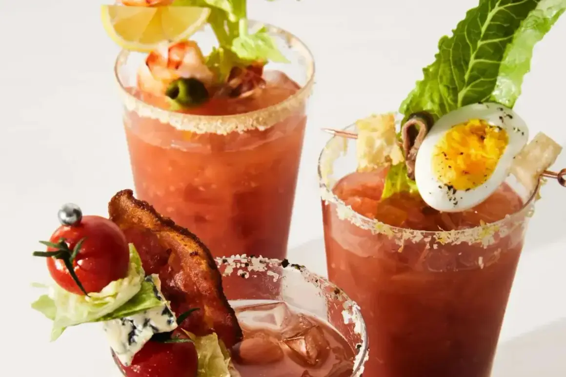 Tre glas med Bloody Mary, dekorerade med räkor, ägg, bacon och grönsaker. En festlig brunchdrink!
