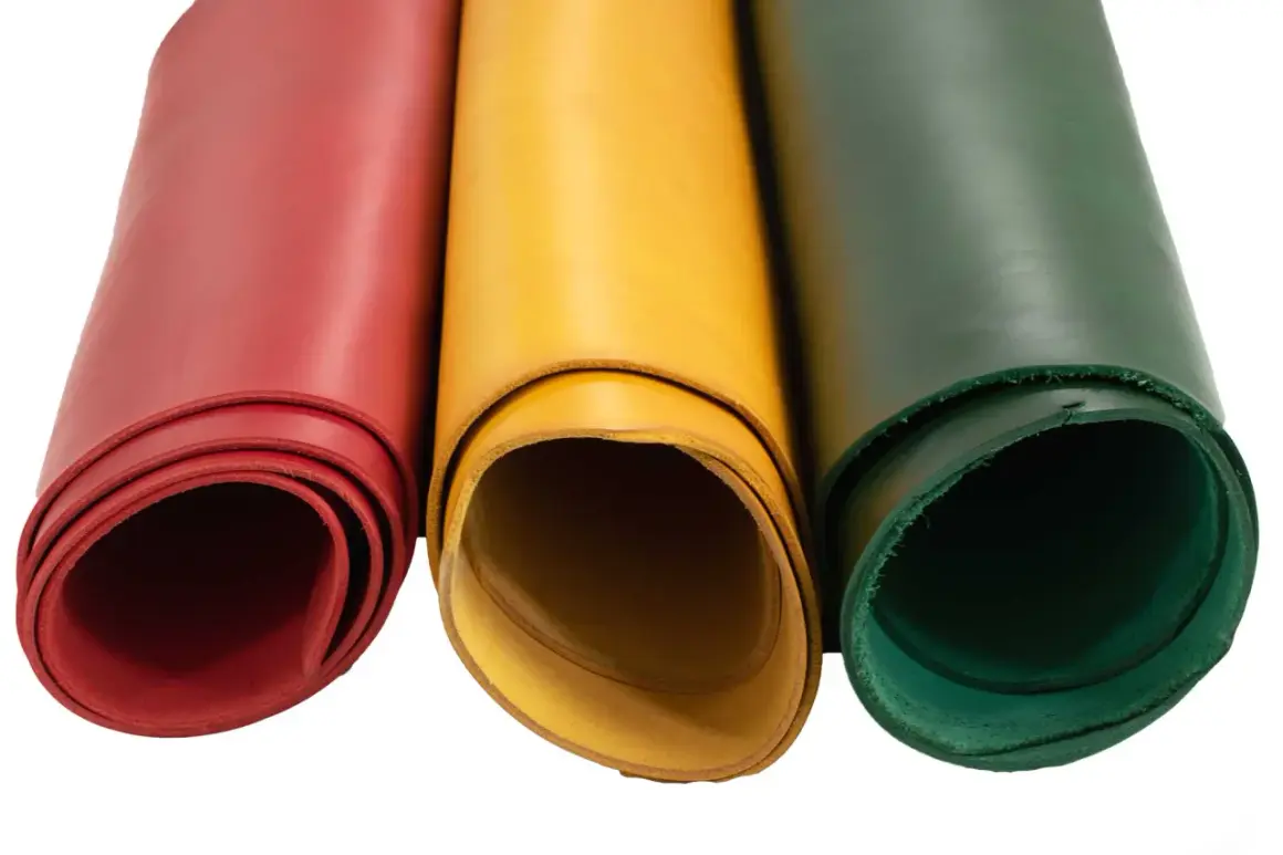Trois rouleaux de cuir végétal aux couleurs vives : rouge, jaune et vert. Parfait pour vos créations artisanales.