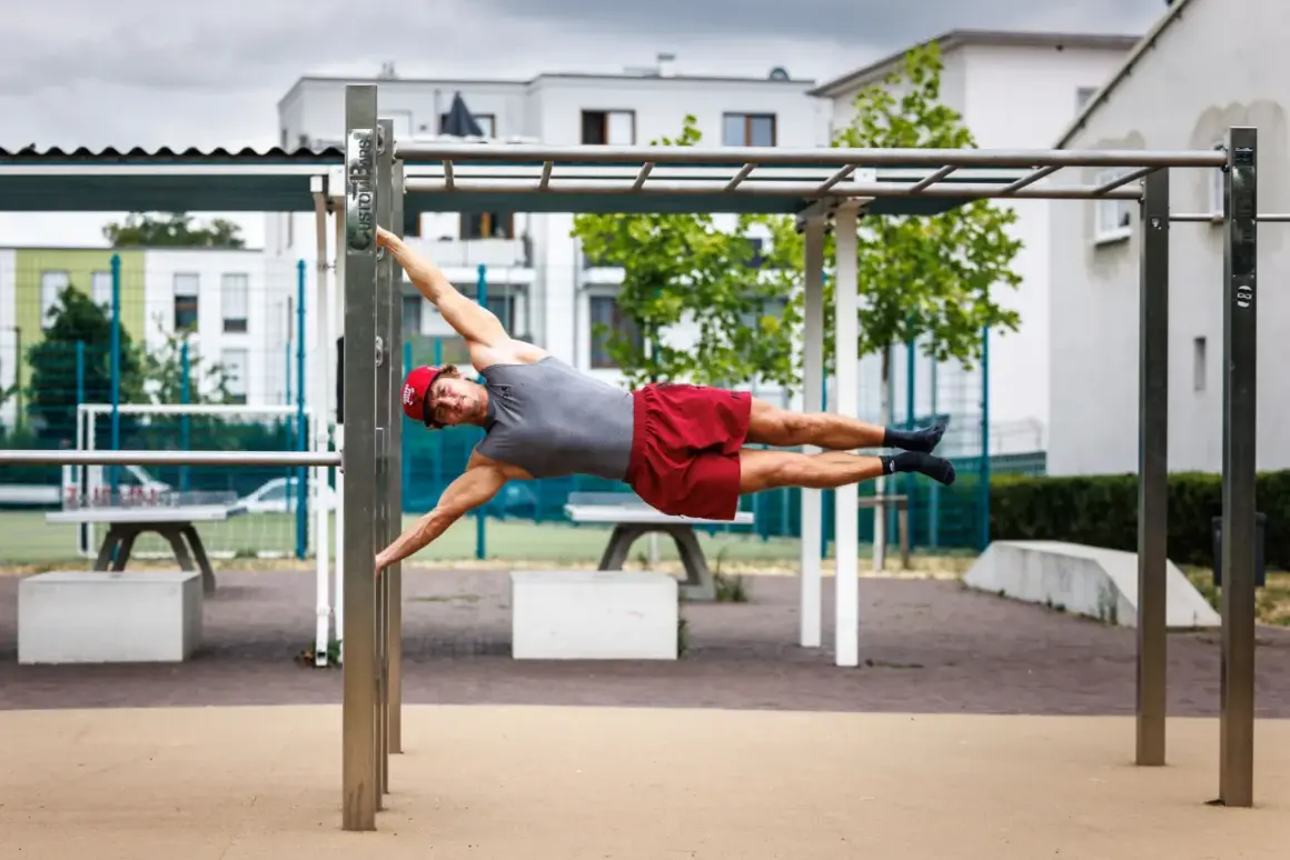 Mann hält die Flagge auf einem Calisthenics-Park. Das zeigt, was ist Calisthenics: Kraft, Balance und Körperbeherrschung.