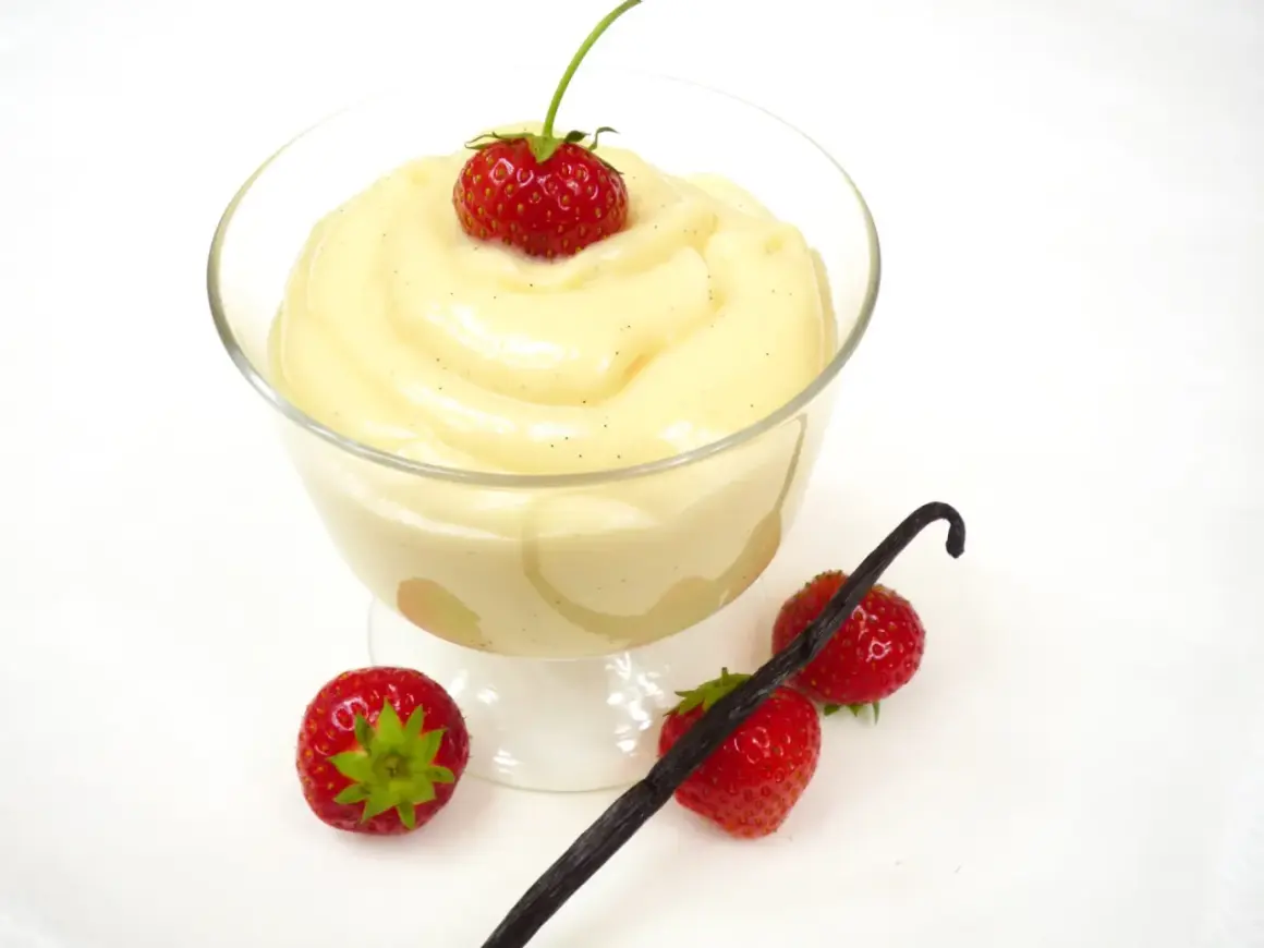 Cremiger Vanillepudding, frisch zubereitet, mit Erdbeeren und Vanilleschote garniert. So einfach ist pudding selber machen!