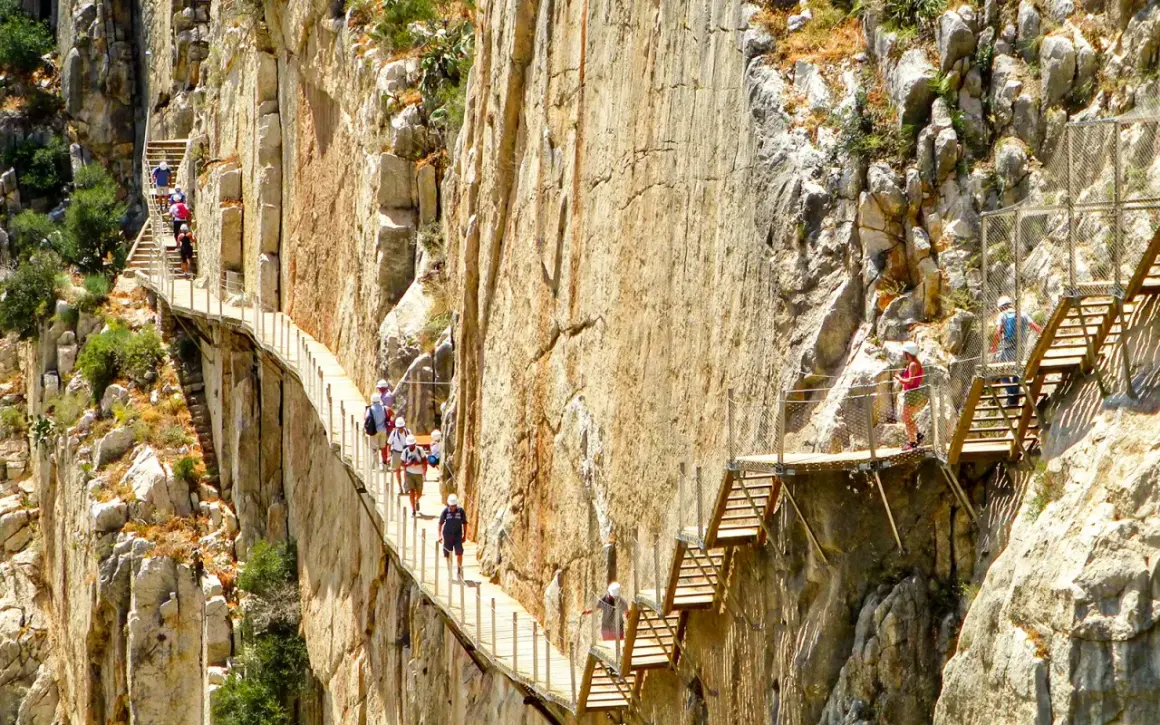Vandrare på den dramatiska gångvägen Caminito del Rey nära Málaga, högt uppe på klippväggarna.