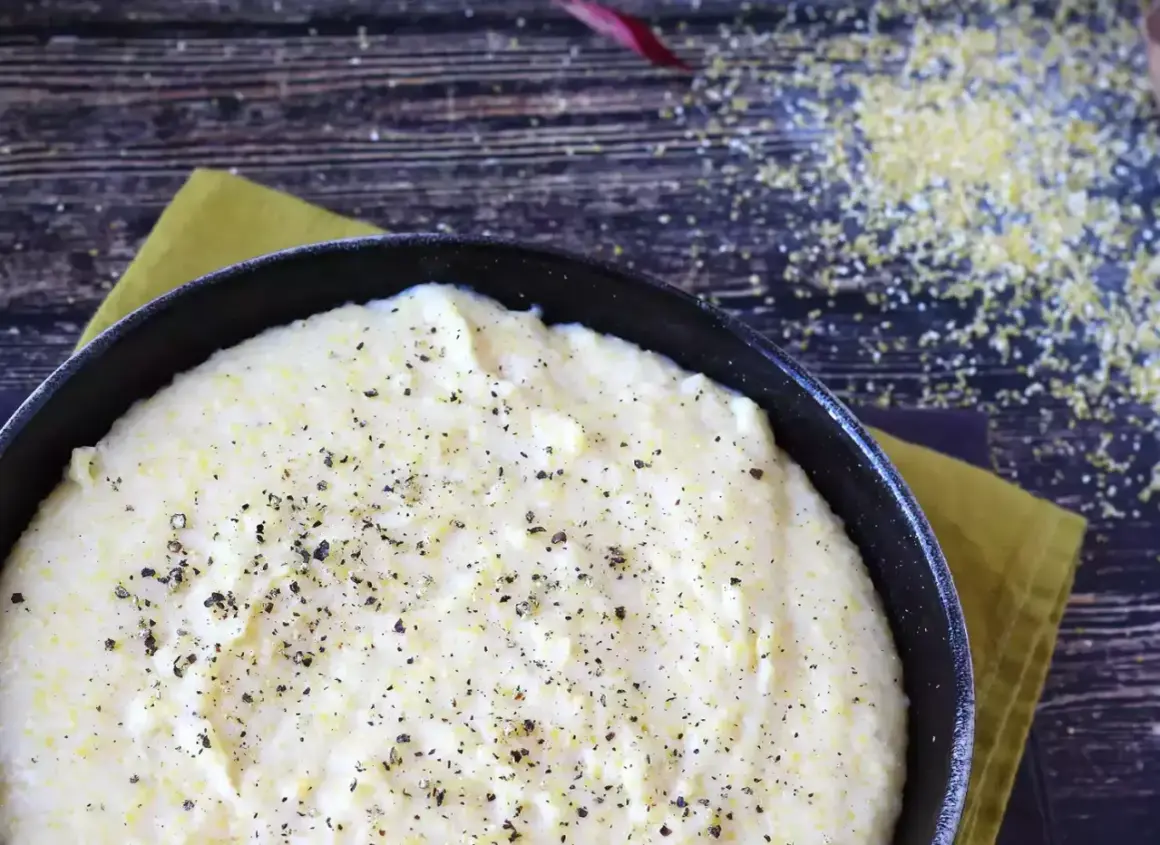 Krämig polenta i gjutjärnspanna, strödd med peppar. Perfekt för ett enkelt polenta recept.