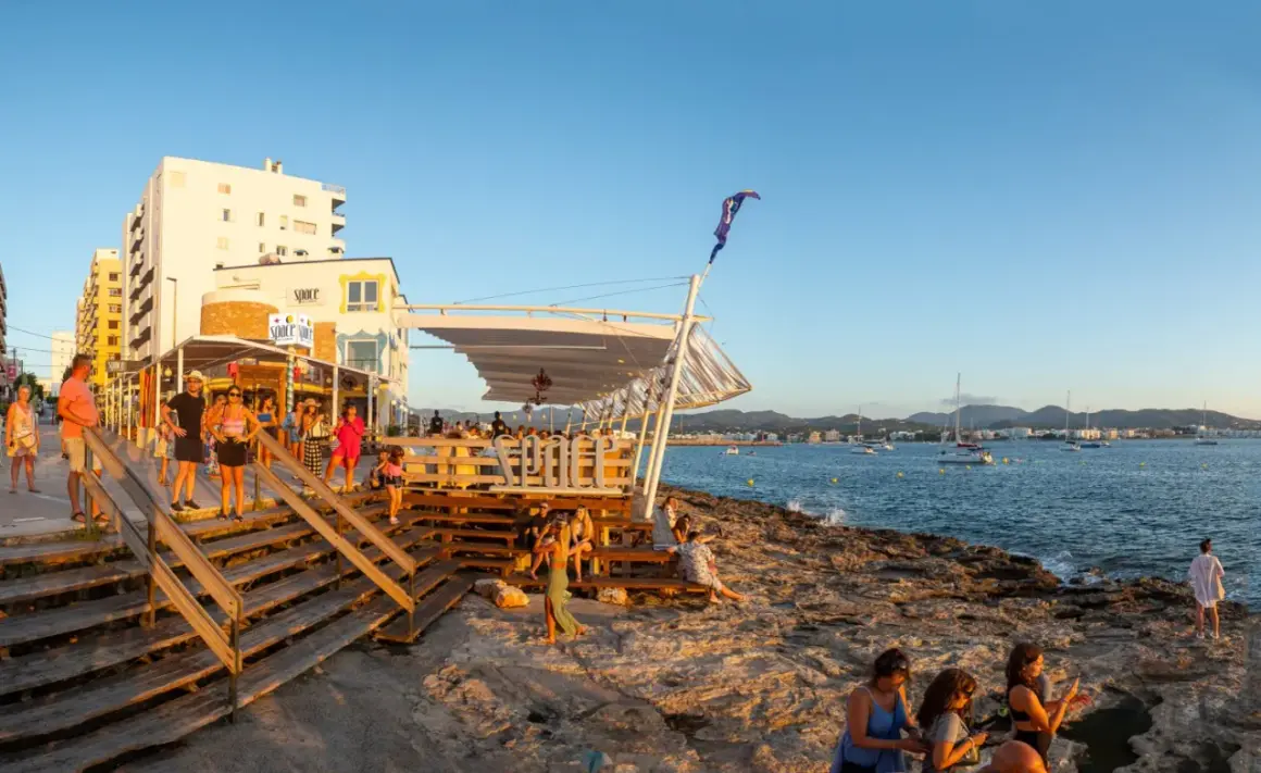 Persone si godono il tramonto sulla costa di Ibiza, vicino alla famosa discoteca Space Ibiza.