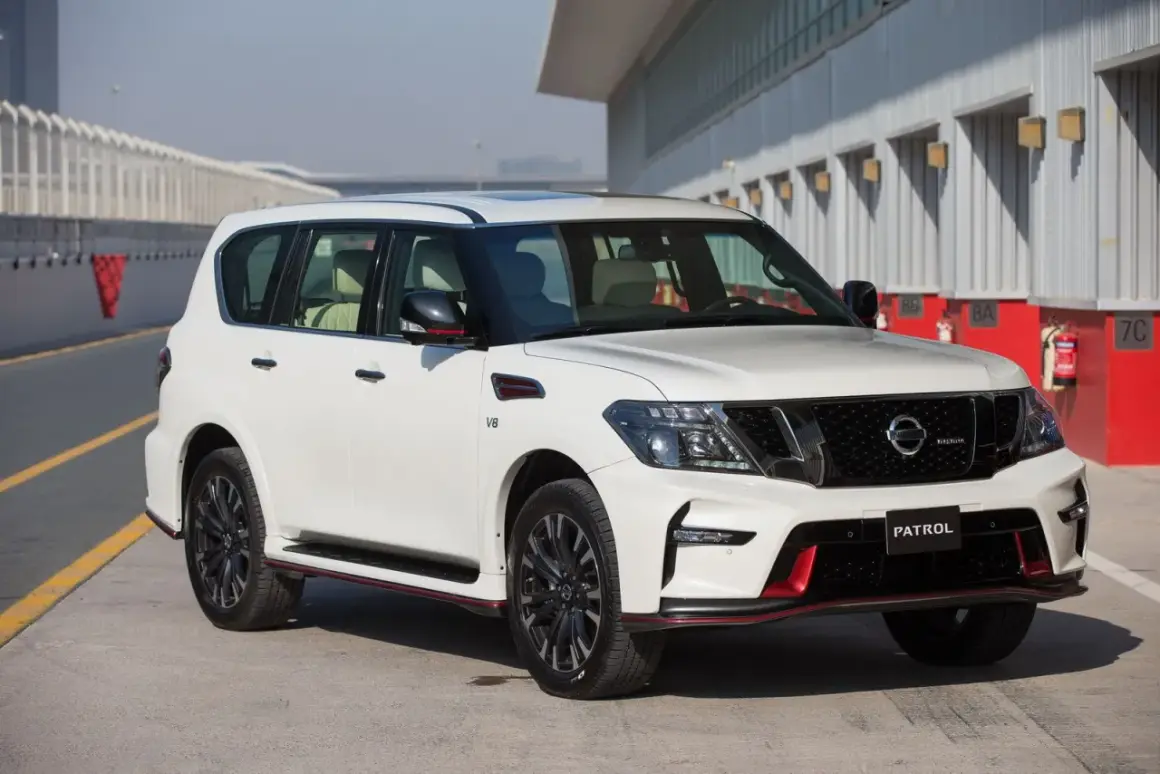 Biały Nissan Patrol Nismo z czerwonymi akcentami stoi na torze wyścigowym.