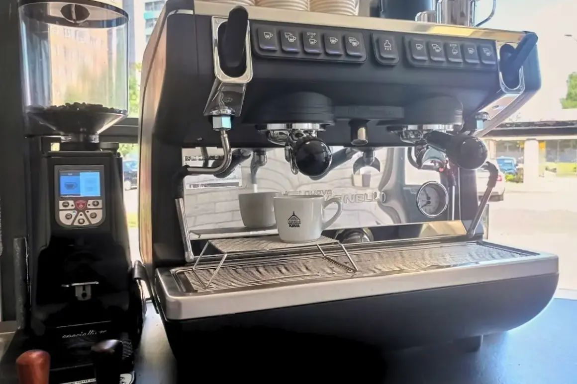 Macchina da caffè professionale con macinacaffè. Pronta per il consumo di caffè, con tazzina in attesa.