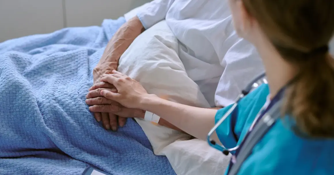 Dłoń pielęgniarki na dłoni pacjenta, symbol wsparcia w leczeniu. Terapia celowana daje nadzieję.