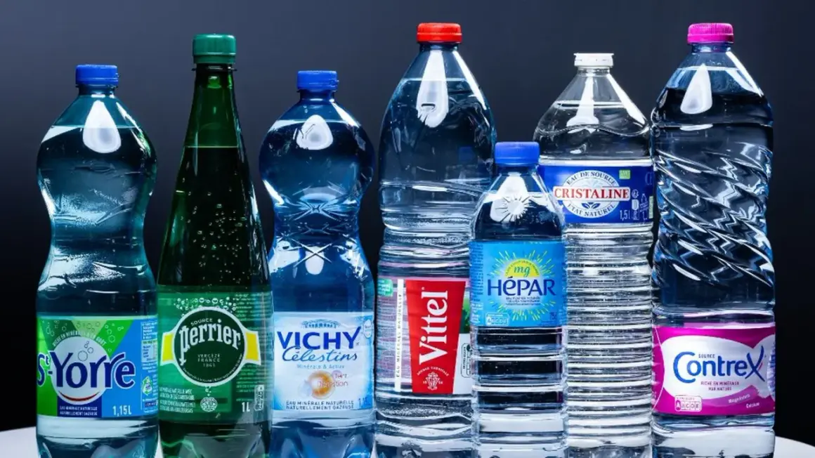 Une rangée de bouteilles d'eau minérale, dont Perrier, Vittel et Contrex, évoque le scandale de l'eau en bouteille.