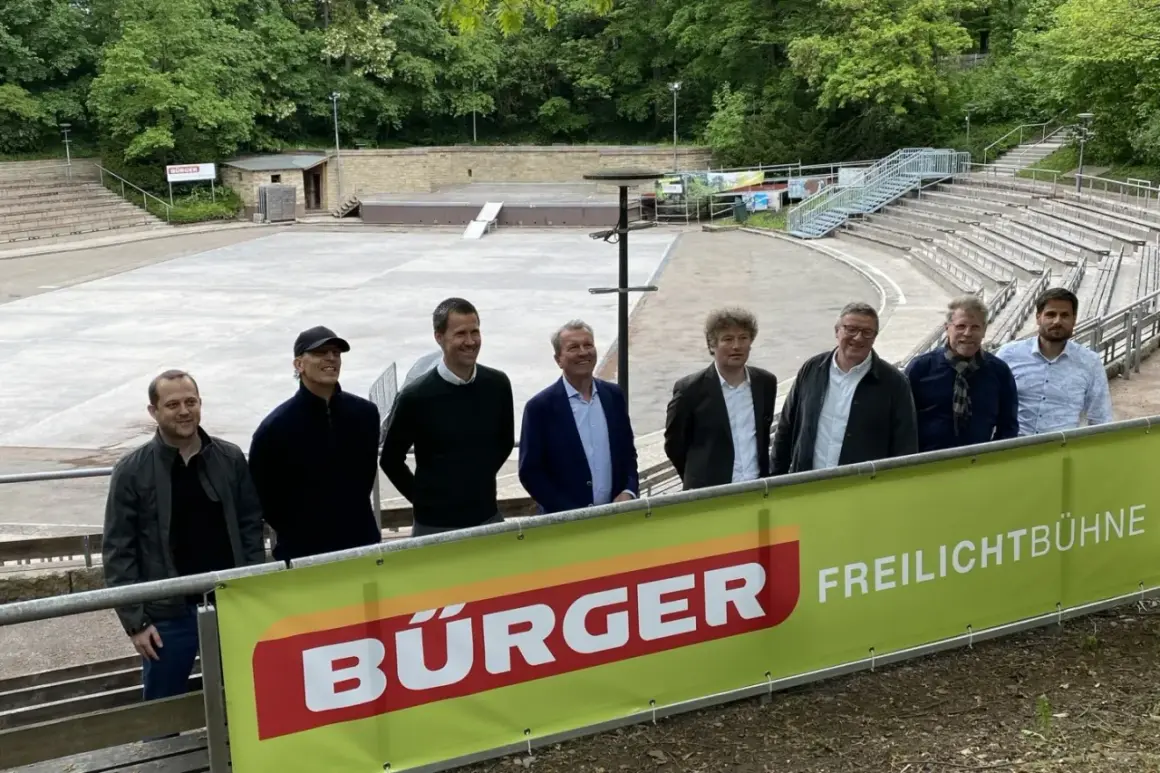Sieben Männer stehen vor einer Freilichtbühne am Killesberg. Die Banner deuten auf bevorstehende Killesberg Veranstaltungen heute.