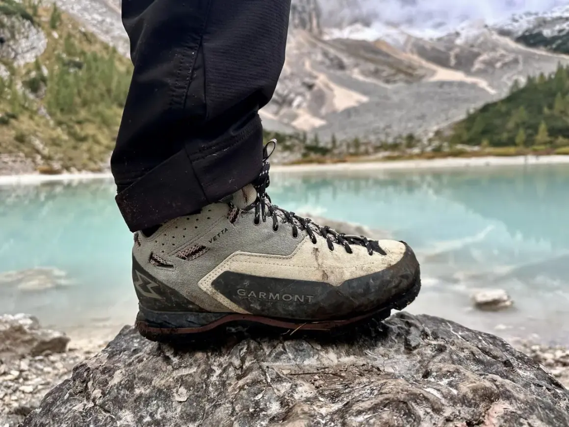 Buty Garmont Vetta GTX na kamieniu, z widokiem na turkusowe jezioro i góry. Gotowe na każdą wyprawę.