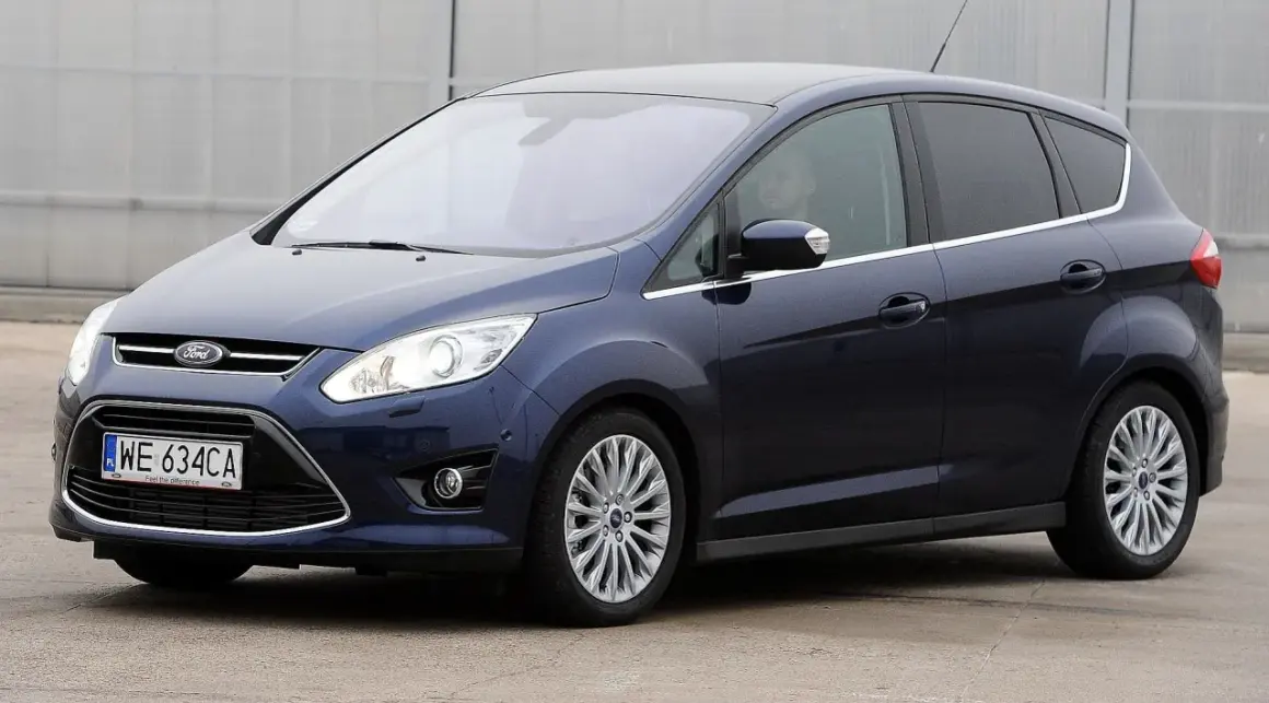 Ciemnoniebieski Ford C-Max, popularny wśród rodzin, widziany z boku. Wiele osób szuka ford c max opinie przed zakupem.