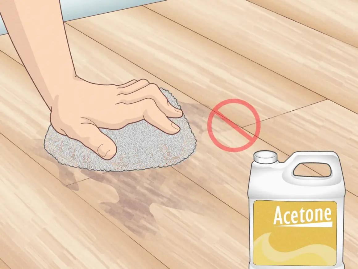 Main tenant, ne pas enlever peinture sur lino avec acétone. Une main frotte le sol avec une éponge.