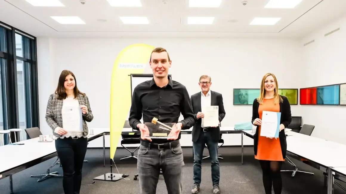 Glückliche Absolventen mit Urkunden und Pokal. Gute Aussichten für die Elektroniker Ausbildung Gehalt Bayern.