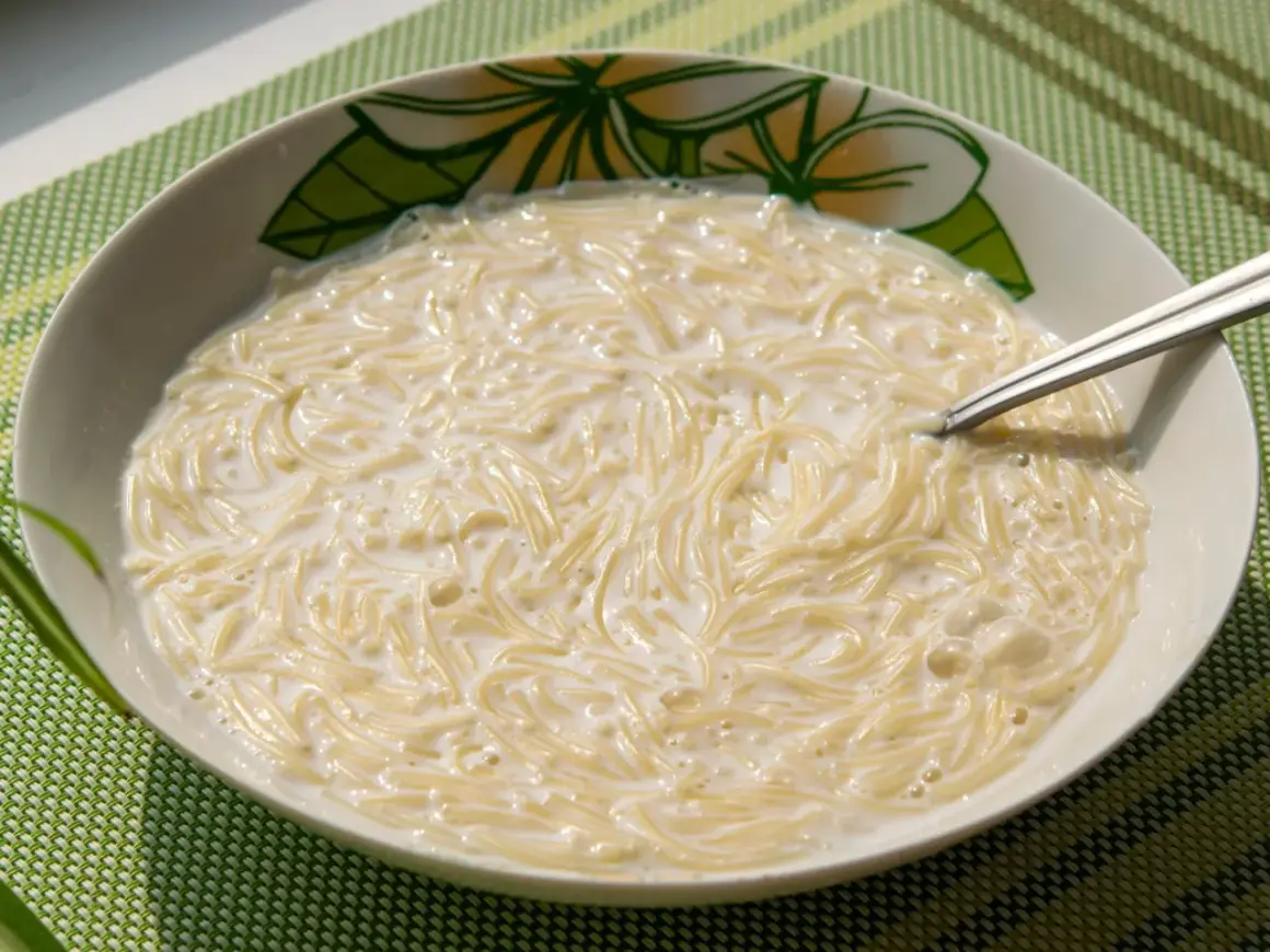 Pyszna zupa z makaronem w mleku, podana w miseczce z kwiatowym wzorem. Idealna na śniadanie lub lekki posiłek.