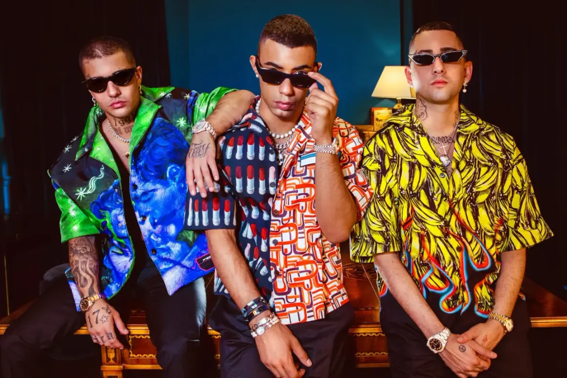 Tre ragazzi con camicie colorate e occhiali da sole, un'immagine che evoca lo stile della dark polo gang.