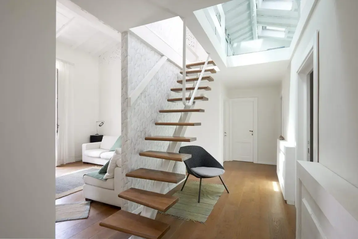 Scala interna moderna in legno e metallo, con design a sbalzo. La normativa scale interne uso privato è rispettata, garantendo sicurezza e stile.