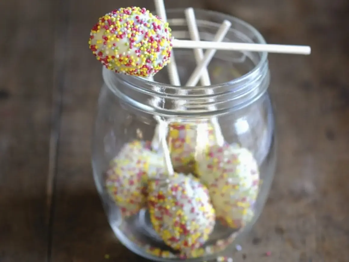 Bunte cake pops mit mascarpone, verziert mit Streuseln, stecken in einem Glas.