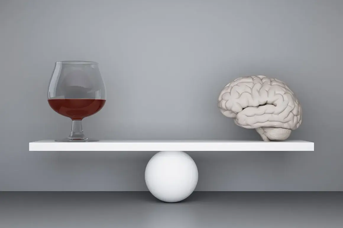 Szalka wagi z mózgiem przechyla się, gdy obok pojawia się kieliszek z alkoholem, symbolizując zmianę zachowania po alkoholu.