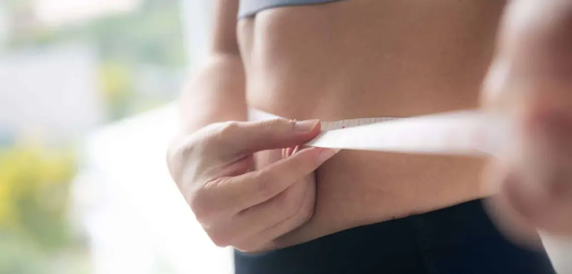 Misura della vita con metro, per capire quante calorie bisogna bruciare al giorno per raggiungere i propri obiettivi di benessere.