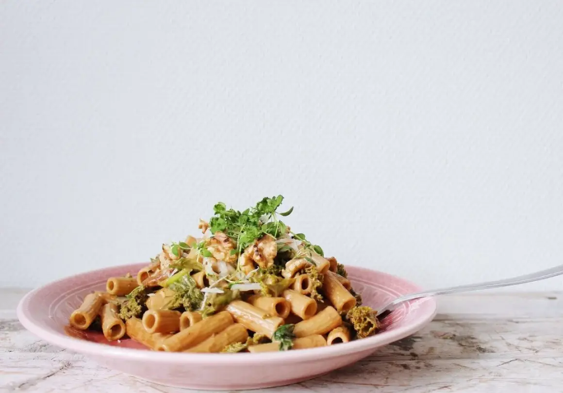 En läcker vegetarisk pasta med broccoli och valnötter, toppad med färska örter.