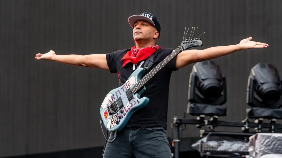 Tom Morello, chitarrista famoso americano, con la sua iconica chitarra "Arm the Homeless" sul palco.