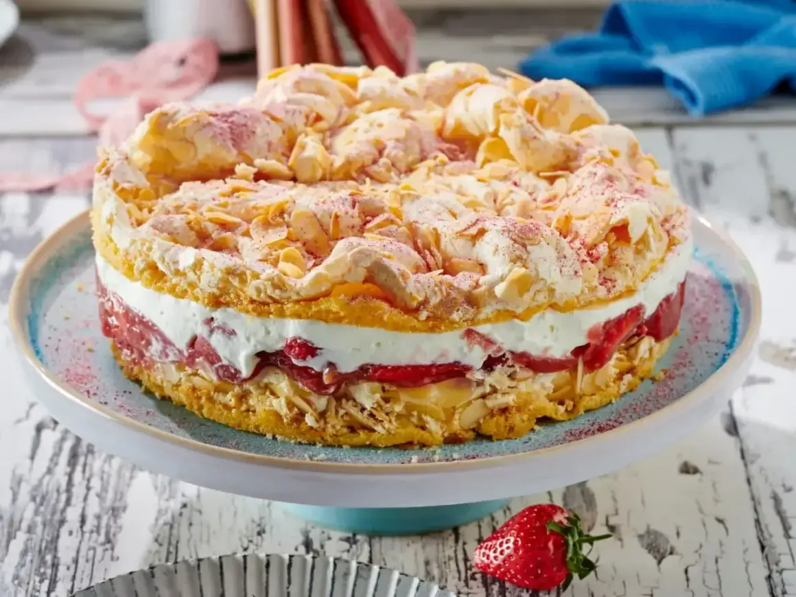 Ein köstlicher Rhabarber Baiser Kuchen mit einer cremigen Füllung und knusprigen Mandelsplittern.