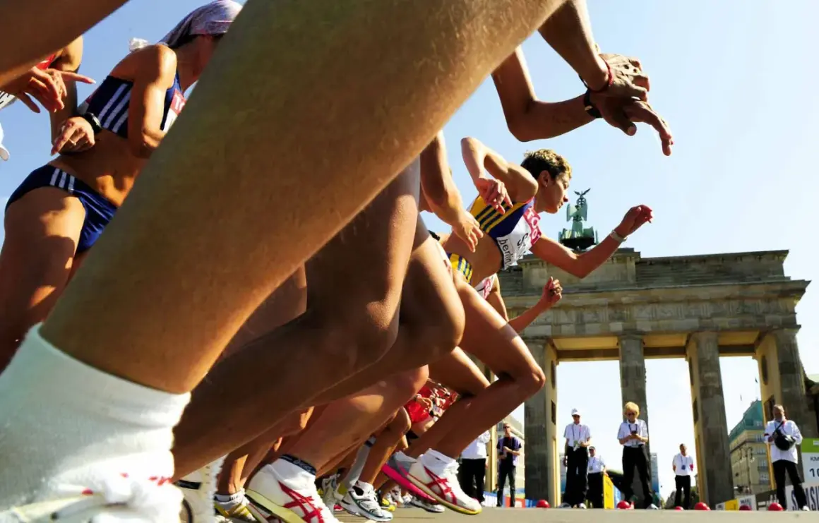 Biegaczki startują do maratonu pod Bramą Brandenburską. Słychać hasła dopingujące biegaczy, którzy walczą o zwycięstwo.