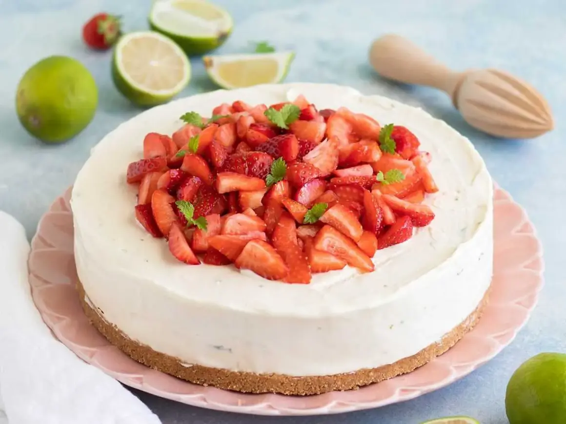En krämig vit choklad cheesecake toppad med färska jordgubbar och mynta. En perfekt sommardessert!