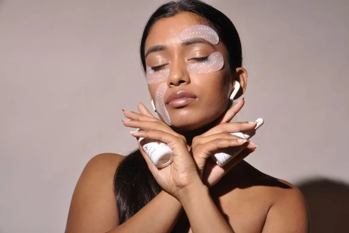 Donna con cerotti per il contorno occhi e creme, per combattere il viso stanco. Rimedi di bellezza per un aspetto radioso.