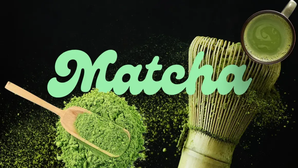 Poudre de matcha verte, cuillère en bois, fouet et tasse de boisson, évoquant le goût matcha authentique.