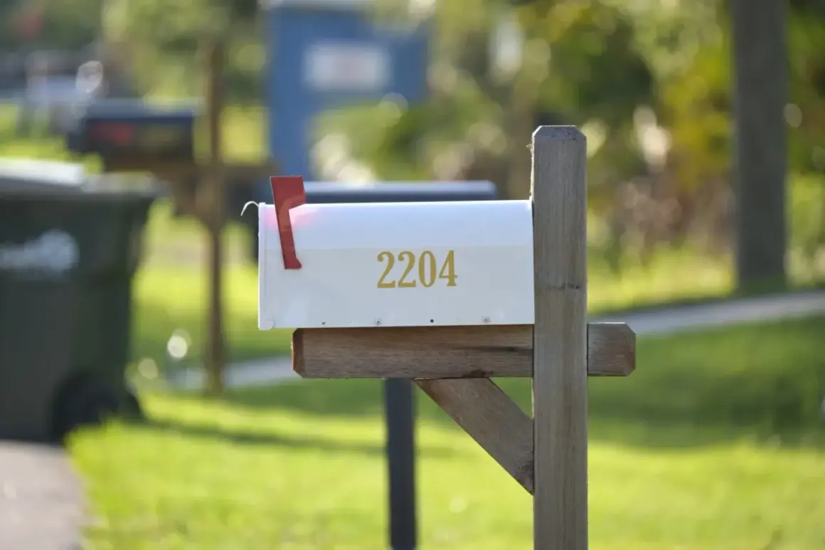 A white mailbox with the number 2204, mounted on a wooden post, ready for mail delivery. This image could be a visual guide on how to install a mailbox.