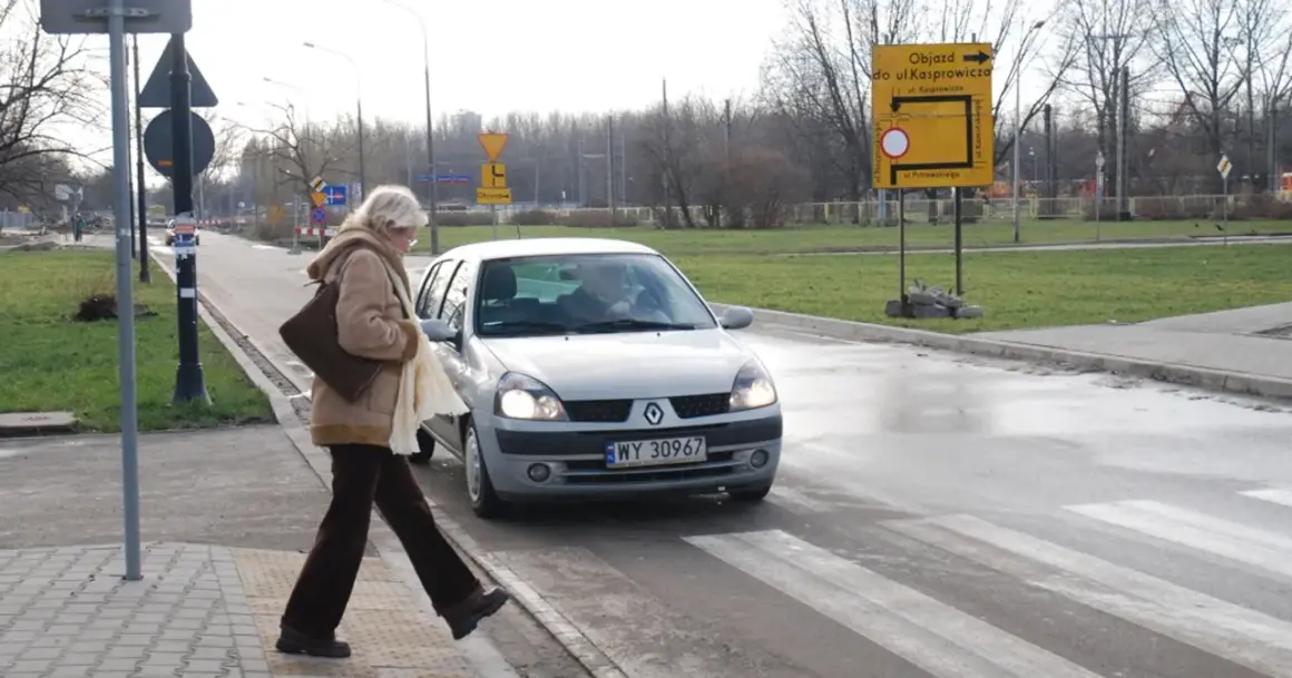 Kobieta na pasach, samochód zbliża się. Kto ma pierwszeństwo na parkingu pieszy czy samochód? Pieszy!