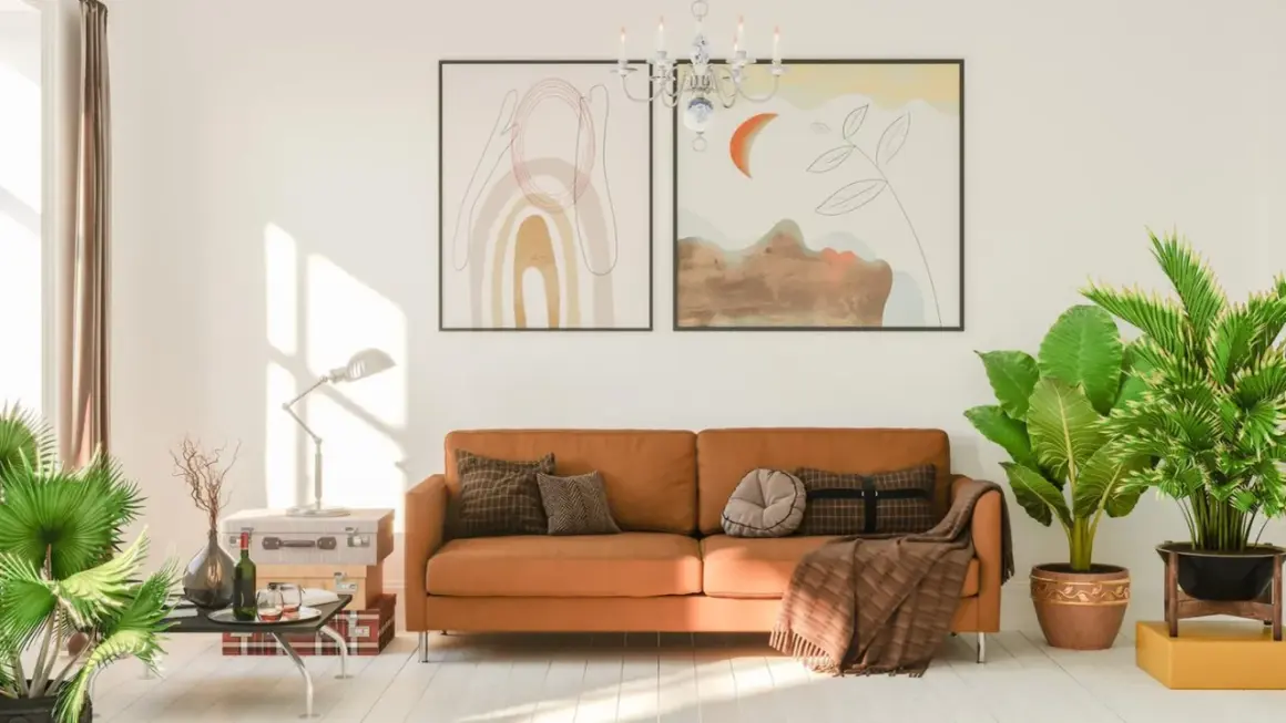 Ein gemütliches Wohnzimmer mit einem orangefarbenen Sofa, das mit Kissen und einer Decke dekoriert ist. Die Sofa-Farbe passt gut zu den Pflanzen und Bildern.