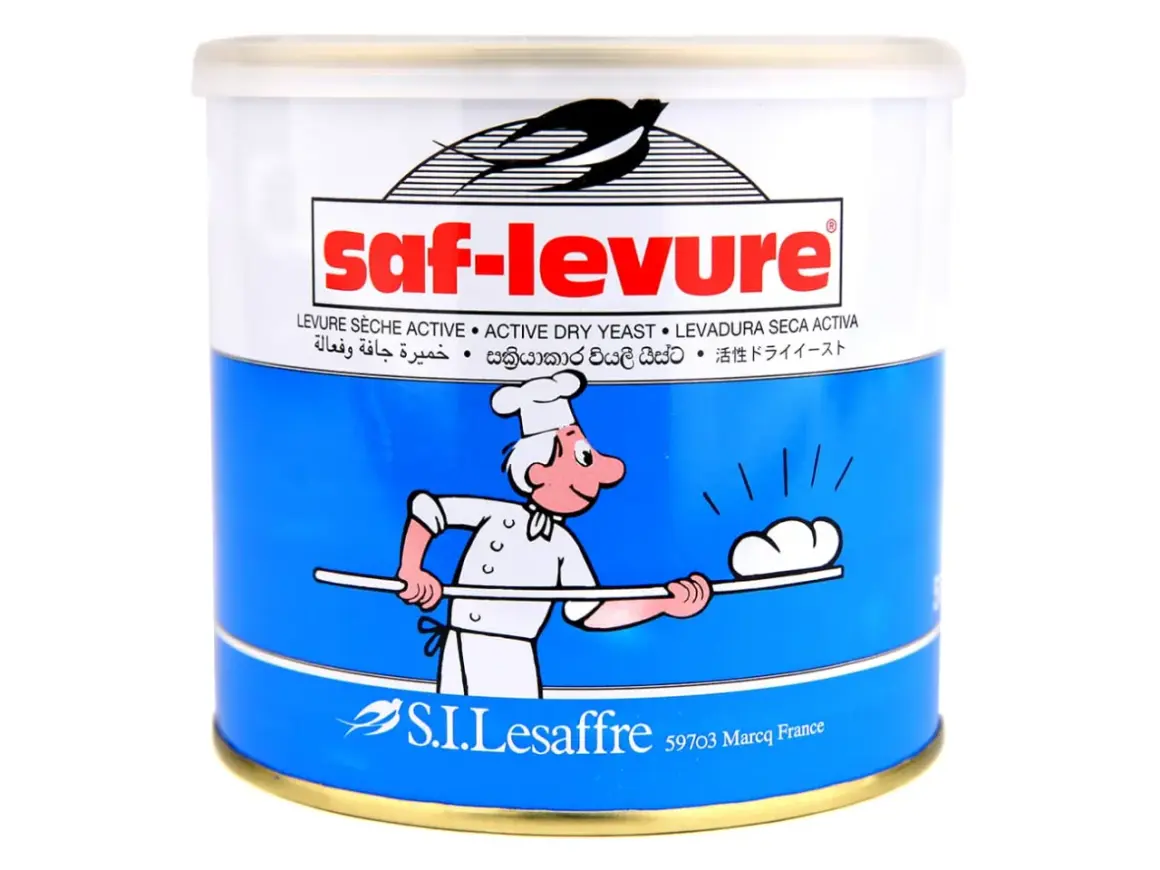 Boîte de levure boulangère déshydratée Saf-Levure, avec un dessin de boulanger souriant.