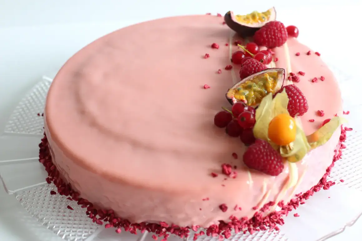 En vacker hallon och passionsfrukt tårta med färska bär och passionsfrukt som dekoration.