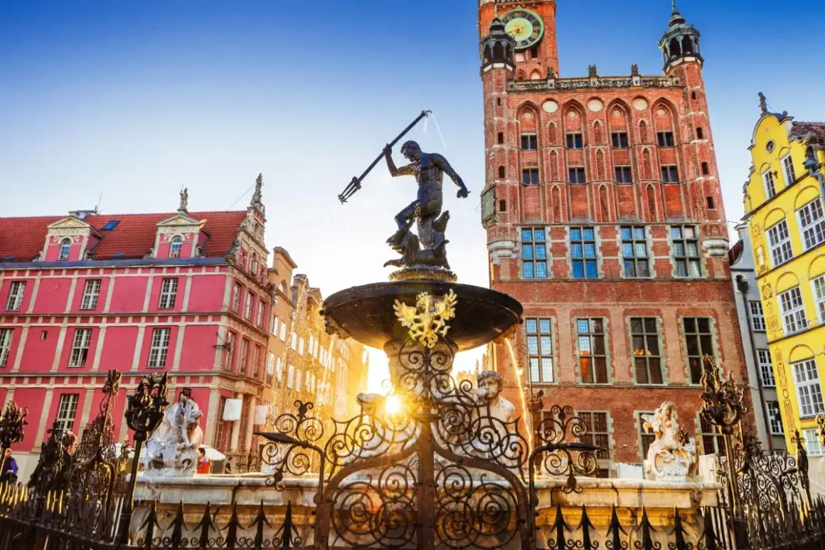 Neptunfontänen i Gamla stan i Gdansk, med sina färgglada hus och ett imponerande tegelhus med klocktorn.