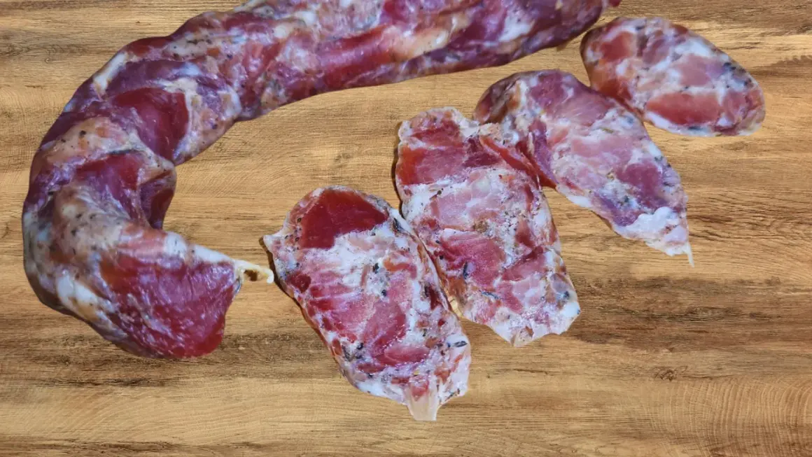 Kiełbasa dojrzewająca, pokrojona w plastry, prezentuje swoje aromatyczne wnętrze. Idealna do domowego wyrobu, gdy szukasz sprawdzonego przepisu.