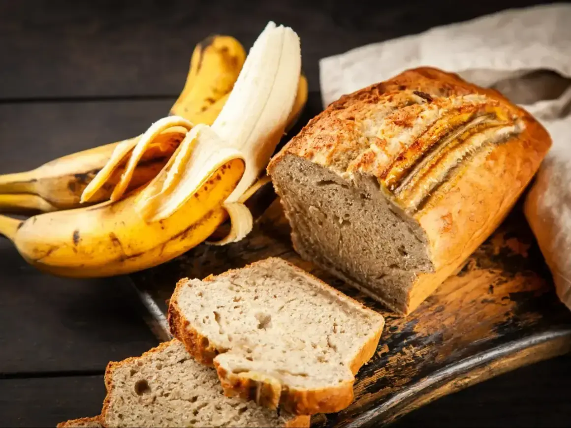 Wilgotne ciasto bananowe, obok dojrzałych bananów, kusi apetycznym wyglądem. Idealne na deser lub śniadanie.