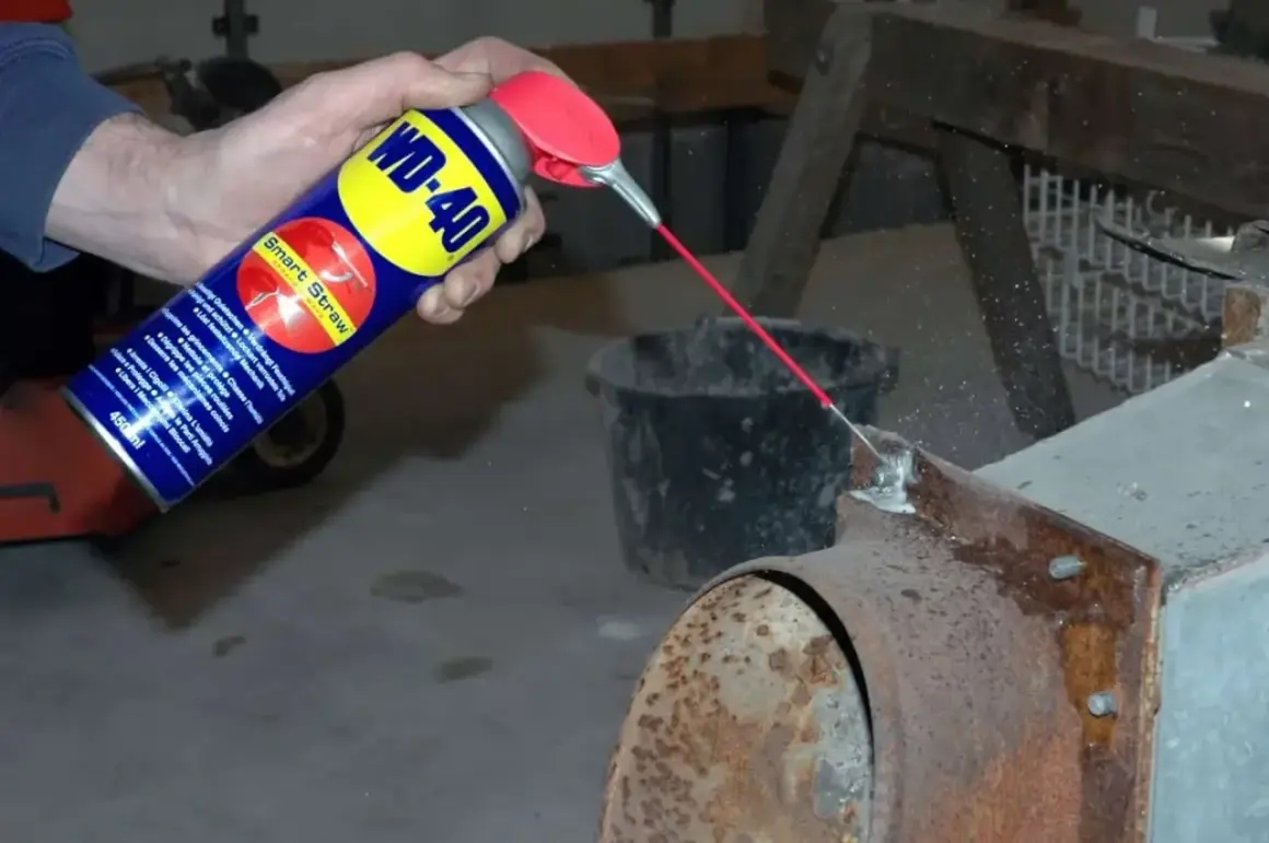 WD-40 wird auf einen verrosteten Kaminofen gesprüht, um Rost zu entfernen.