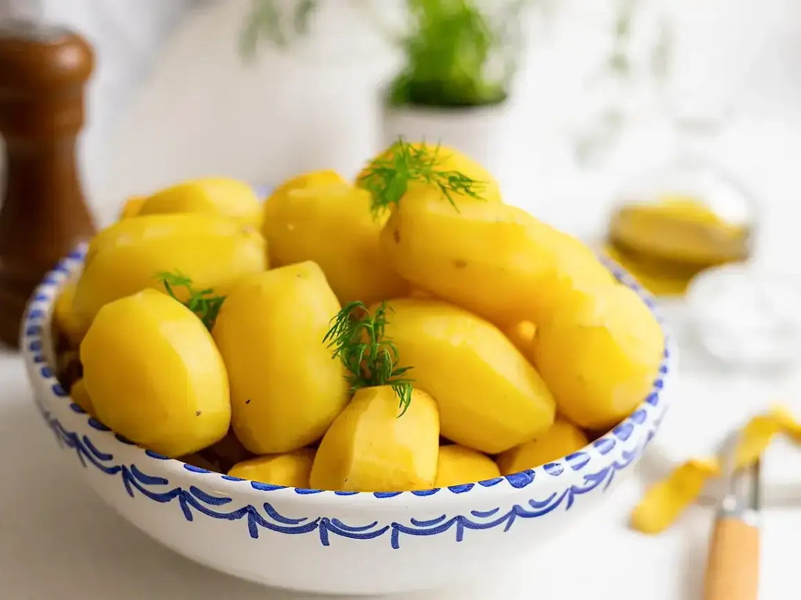 En skål med nykokta, gula potatisar, garnerade med dill. Perfekt för att koka potatis till middagen.