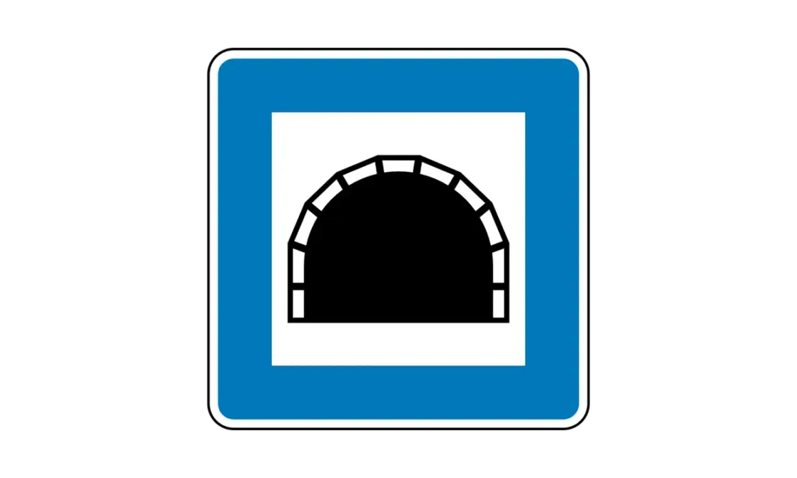 Blaues Verkehrsschild mit weißem Rahmen, das ein schwarzes Tunnelportal zeigt. Dieses tunnel schild warnt vor der Einfahrt in einen Tunnel.