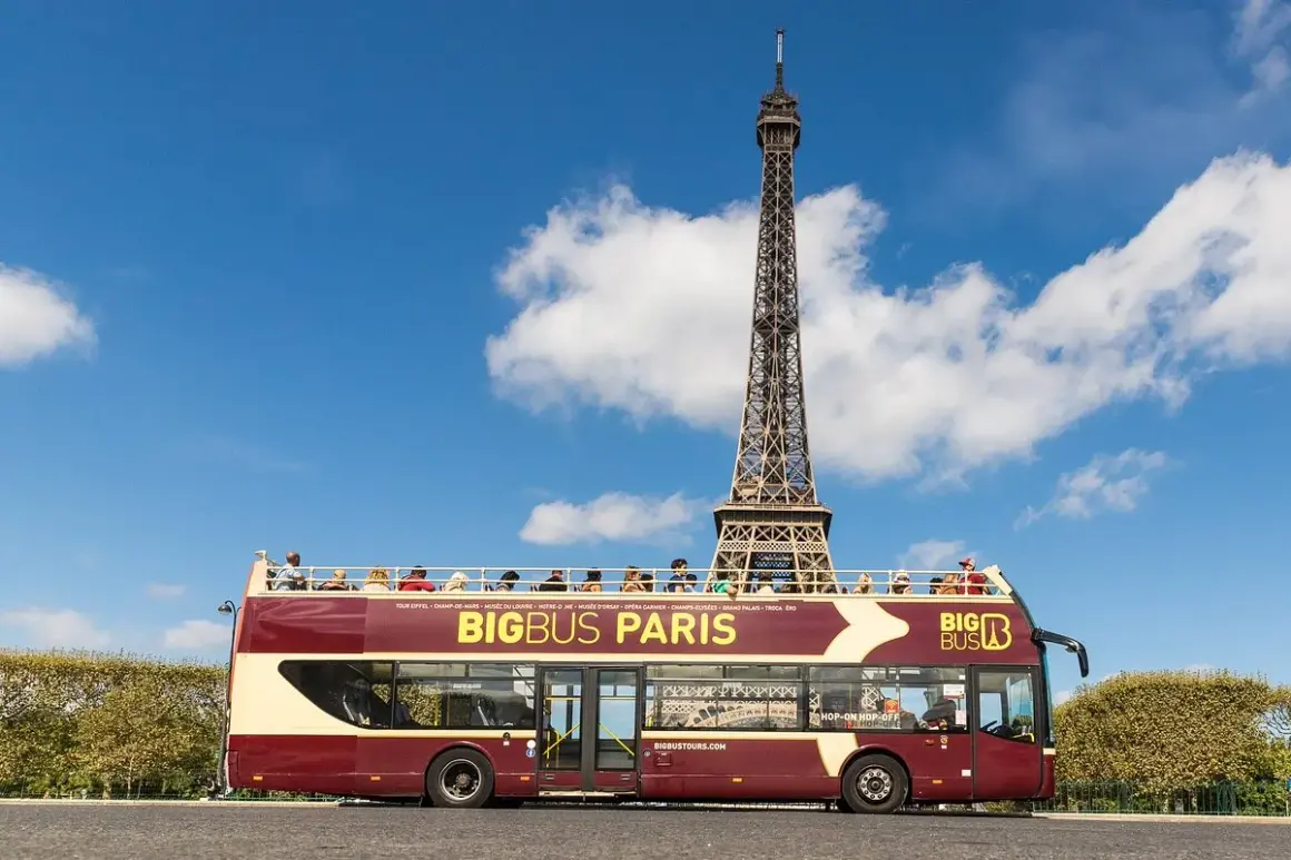 Autobús turístico Big Bus Paris con la Torre Eiffel de fondo. Turistas disfrutan del viaje en la cubierta superior.