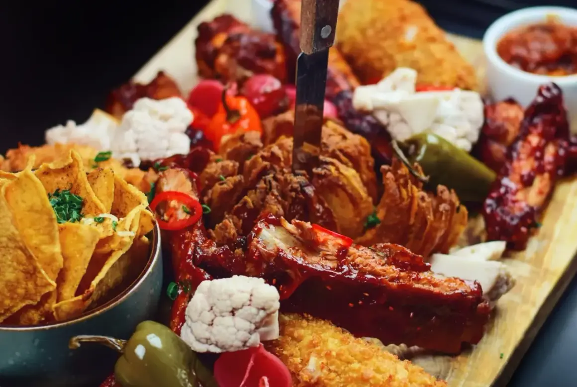 Talerz pełen pyszności: żeberka, skrzydełka, nachos i chrupiąca cebula. Idealna uczta, którą znajdziesz w najlepszych restauracjach w Sopocie.