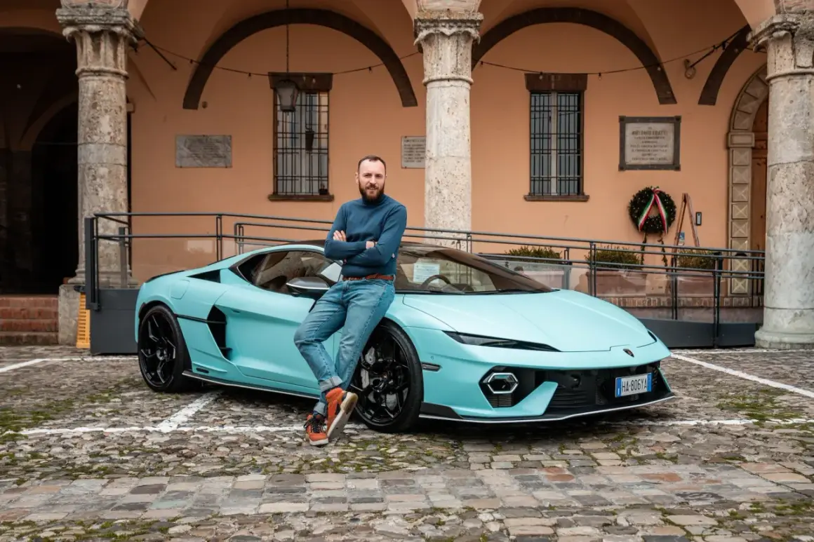 Mężczyzna opiera się o turkusowego Lamborghini Temerario na brukowanym dziedzińcu.