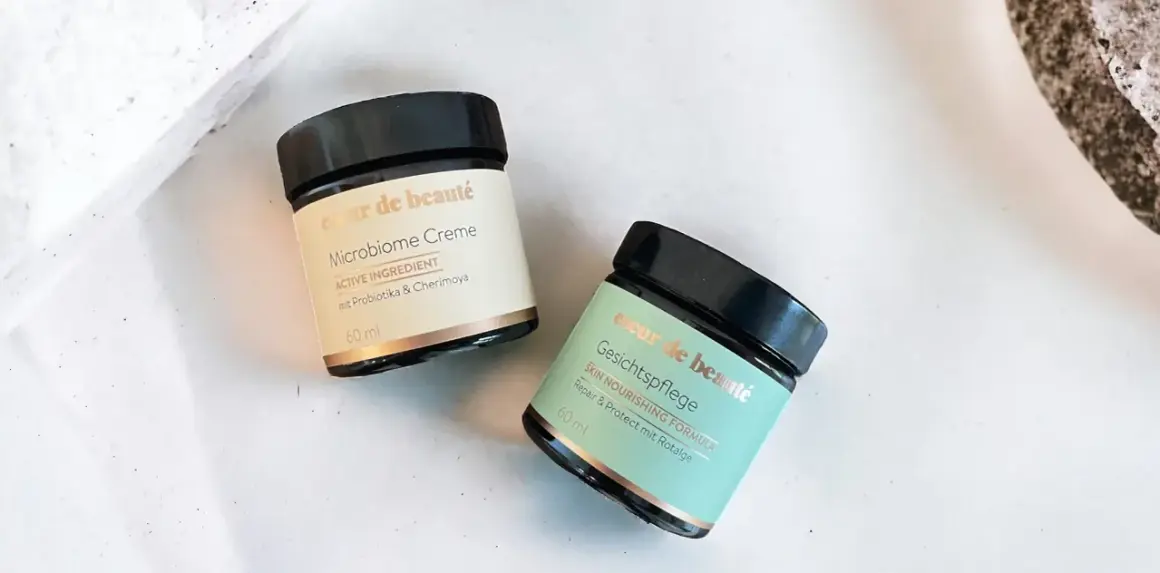 Zwei Tiegel "coeur de beauté" Microbiome Creme und Gesichtspflege, die auf probiotische Hautpflege setzen.