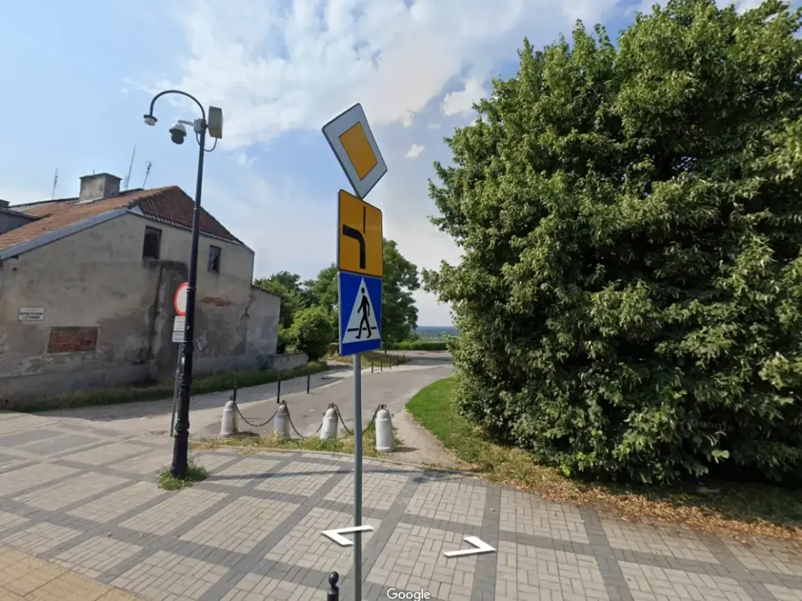 Znak pierwszeństwo łamane kierunkowskaz informuje o skręcie w prawo i ustąpieniu pierwszeństwa. Obok znak przejścia dla pieszych.