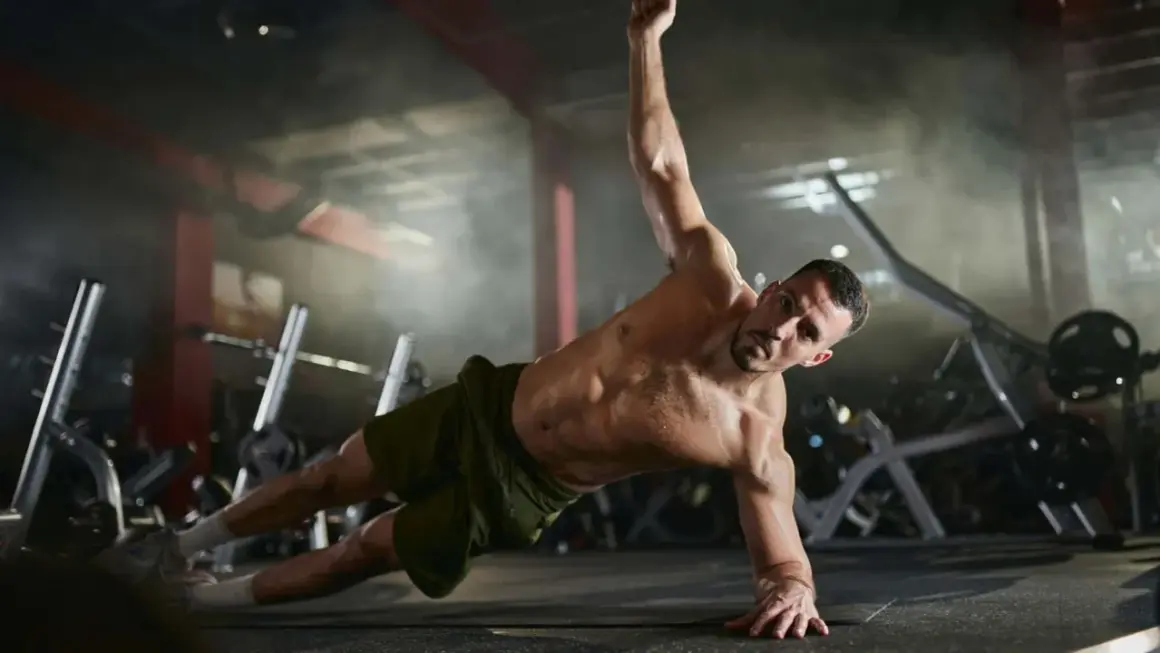 Mann trainiert seine **abs muskeln** in einem Fitnessstudio. Er macht eine seitliche Plank-Übung, wobei sein Körper gerade und angespannt ist.