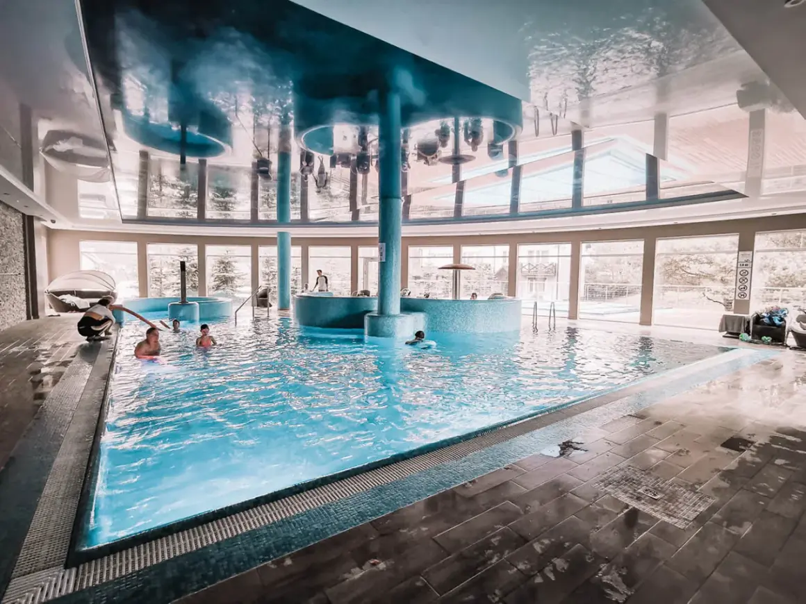 Relaks w basenie hotelu Tristan. Dzieci pluskają się w wodzie, a dorośli odpoczywają przy basenie.
