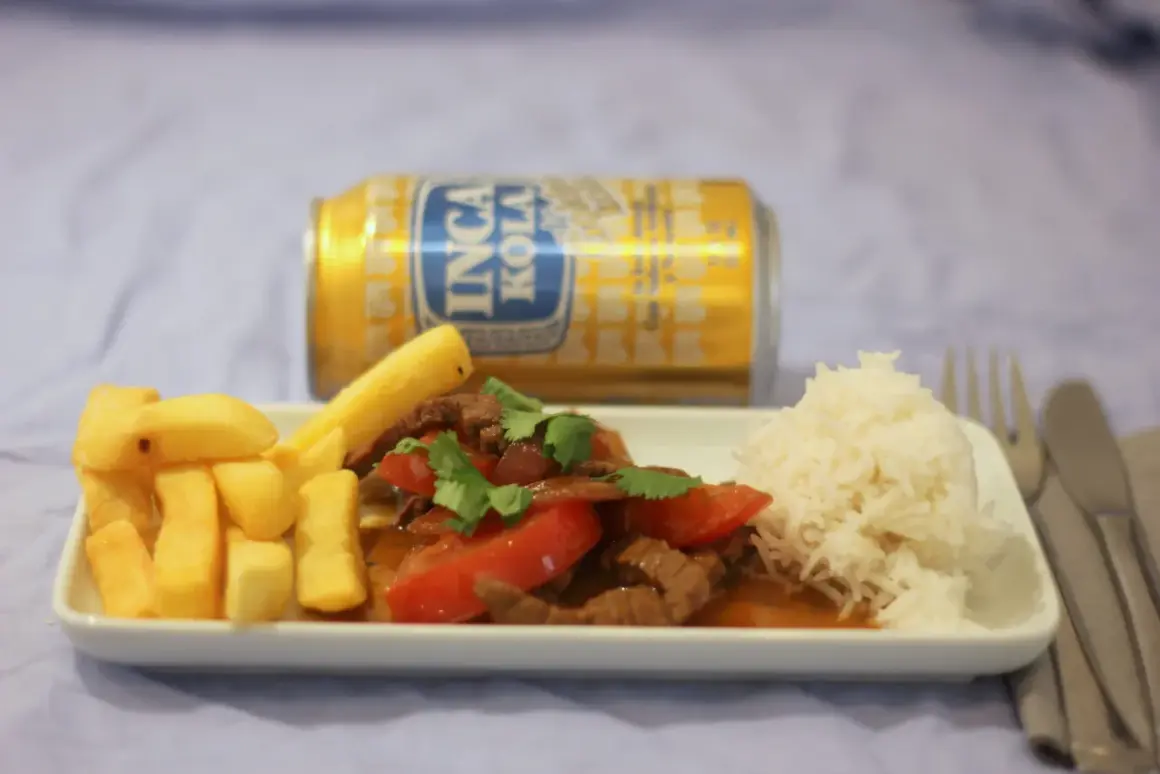 Lomo Saltado mit Pommes, Reis und Inca Kola. Ein herzhaftes Gericht, das den Gaumen erfreut.