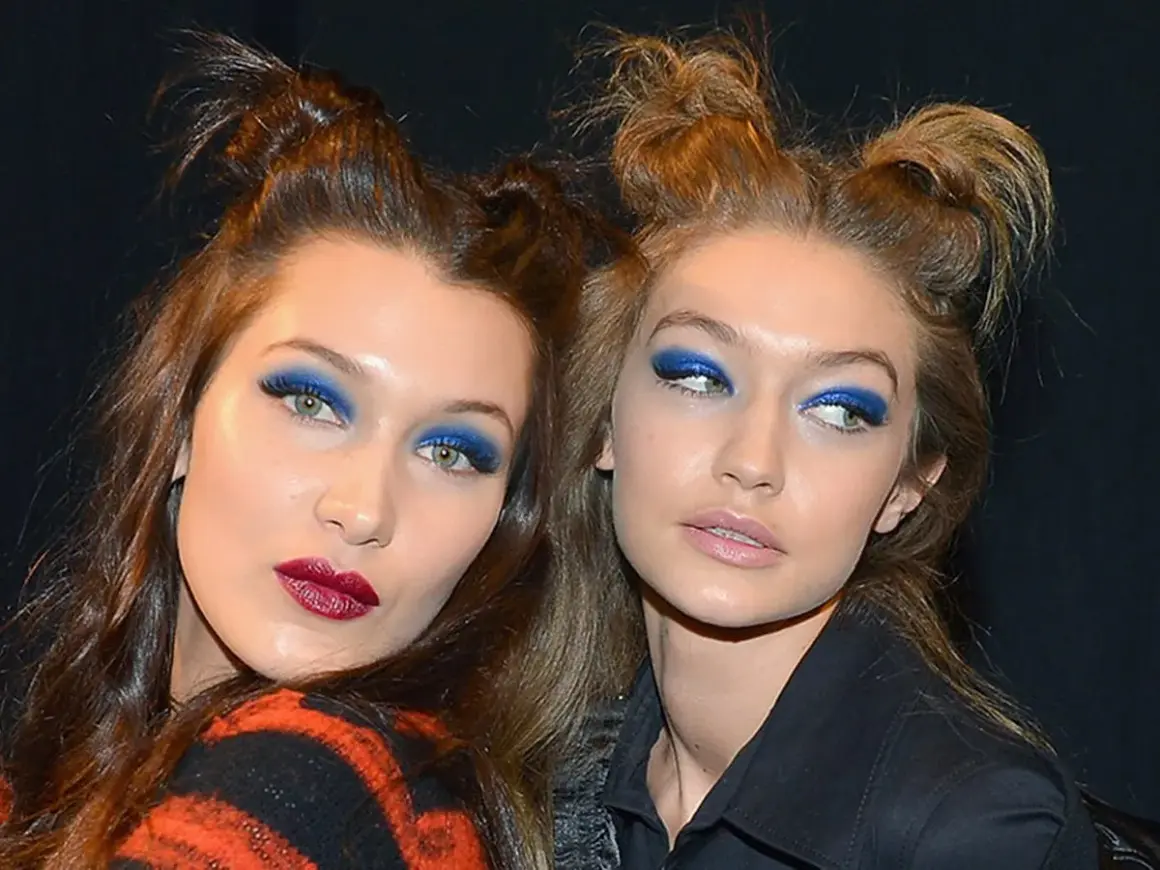Due modelle con un'audace acconciatura semiraccolto e un vivace trucco occhi blu.